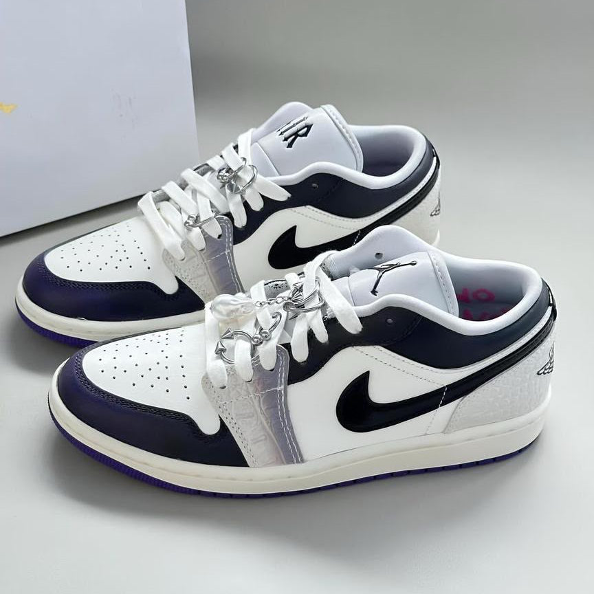 Nike Air Jordan 1 Low sneakers in white and dark concord with black Swoosh, Jumpman ankle logo, and silver lace charms — 100% authentic men's luxury sneakers