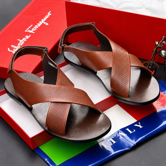 A pair of black leather criss-cross strappy sandals with adjustable ankle straps, displayed on a white surface next to a yellow beaded bracelet.