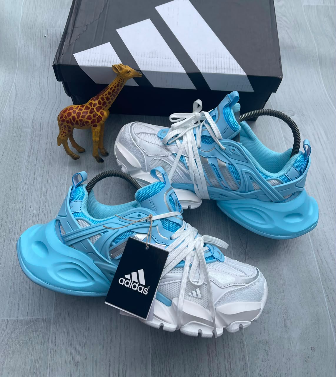 Adidas chunky mesh sneaker in sky blue and white with sculptural rubber sole, coiled heel detail, and three-stripe branding — Swingdot Luxe