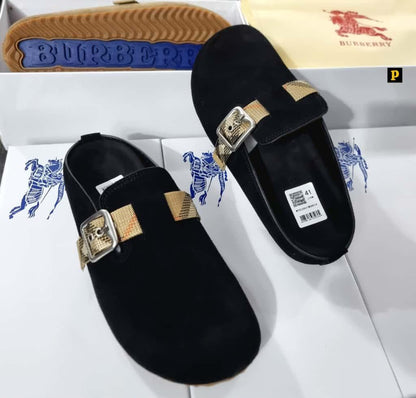 Burberry black suede mule slides with signature Burberry check gold buckle strap, displayed on Burberry branded box — 100% authentic men's luxury footwear