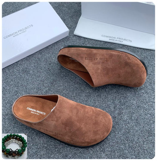 Common Projects tan suede mule slides Made in Italy with gold serial number stamp on insole, displayed beside white Common Projects box — 100% authentic men's luxury footwear