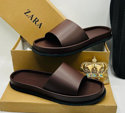 Zara dark brown leather platform slide sandals with wide single strap and black rubber outsole, displayed on Zara kraft box with gold crown prop — 100% authentic men's luxury slides