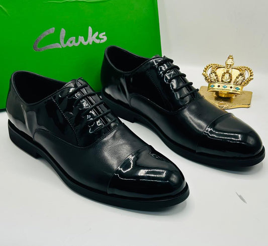 Clarks black patent leather cap-toe Oxford lace-up shoes displayed against Clarks green box with gold crown prop — 100% authentic men's formal footwear